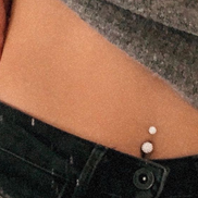 Navlepiercing med hvid sten.