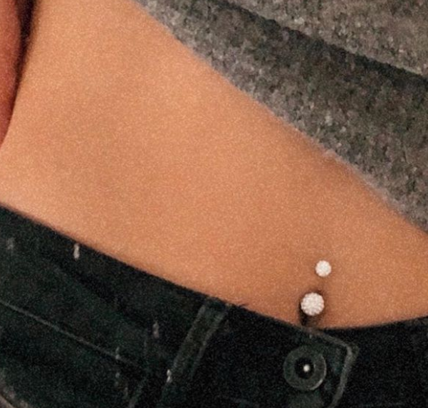 Navlepiercing med hvid sten.